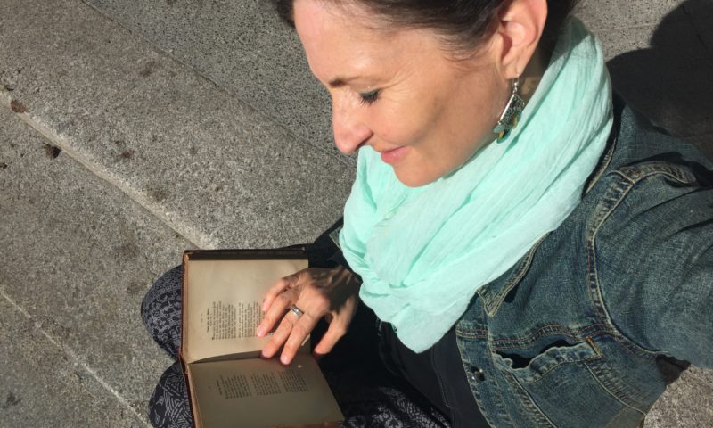 Kathrin Clara Jantke liest ein Buch mit altdeustcher Schrift aus einer Bibliothek